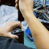 Technician bench-testing a vehicle-specific digital cluster during warranty review