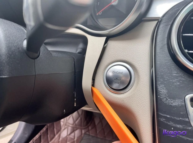Plastic trim tool releasing the lower steering-column trim on a Mercedes W205
